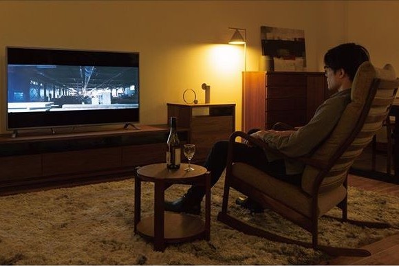 リラックスチェアに座り映画鑑賞を楽しむシーン